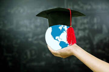 Graduation cap on woman holding Earth globe with graduation hat