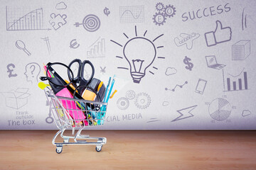 stationery inside a shopping trolley with doodles on the wall background
