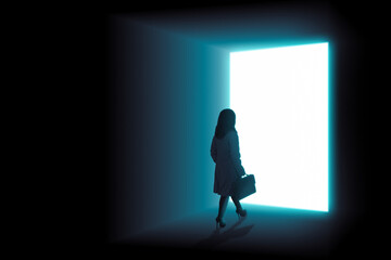Businesswoman with briefcase walking towards an opened door with bright light