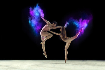 Passion. Young graceful ballet dancers, man and woman ion beige bodysuits dancing with powder explosion against black studio background. Concept of art, festival, beauty of dance, inspiration, youth