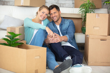 happy couple unpacking boxes and moving into a new home