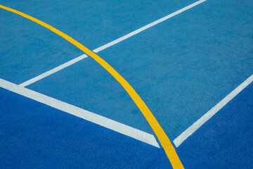 Fototapeta na wymiar Sport field court background. Blue rubberized and granulated ground surface with white, yellow lines on ground. Top view