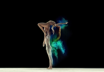 Attractive, talented, young man and woman, ballet dancers making colorful performance with powder...