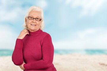 Fototapeta na wymiar Portrait of senior woman posing by the sea