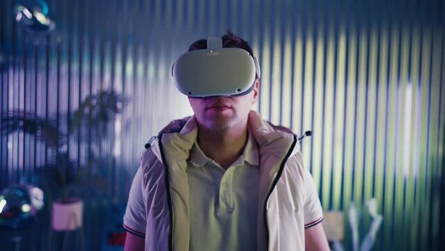 Man wearing VR glasses turns head from side to side