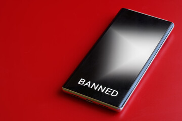 Modern mobile phone is a smartphone with the inscription "banned" on a red background. The concept of a ban on the use of a smartphone, cellular communication and gadgets. Photo.
