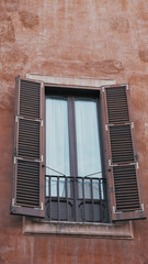 Open italian window on vintage wall with flowers