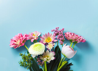 Bouquet of beautiful spring flowers on pastel blue table top view Greeting card. Generative AI