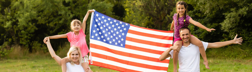 Fototapeta Happy family in field with USA, american flag on back. obraz