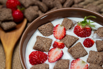 A plate of chocolate pads with milk and strawberries. Delicious and healthy breakfast