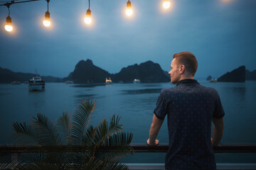 Man enjoying magnificent night view from cruise ship between islands. Popular tourist destination...