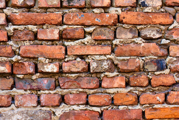 Old brick wall background, brick wall texture, structure. old broken brick, cement joints, close-up. crumbling from old age.