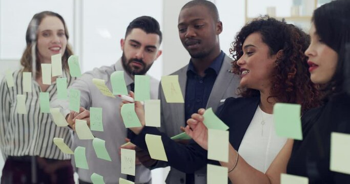Young business people, planning and glass board with discussion, brainstorming or sticky note with teamwork. Black man, women and moodboard with ideas, team building or writing for solution in office
