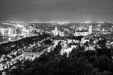 Malaga, Andalusia, Spain: Panoramic aerial view of Malaga coastline, Malaga Cathedral, old town and port at twilight in black and white
