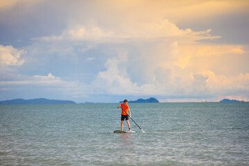 Naklejka premium Man on stand up paddle. Water and beach sport