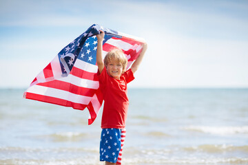 Kids with American flag on beach. 4th of July.
