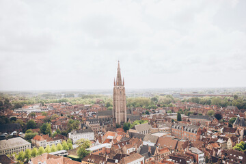 Fototapeta na wymiar aerial view of terracotta roofs and tall church buildings in an old european city belgium europe belltower