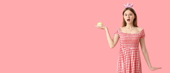 Surprised young woman with birthday cake on pink background with space for text