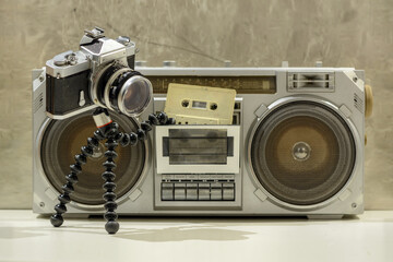 An old camera putting cassette into a boombox  