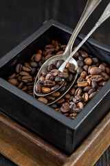 Roasted coffee beans in a wooden box and a metal spoon