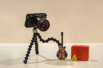 A photo of a camera playing electric guitar with a orange amplifier on the background with white...