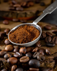 Roasted coffee beans and a spoonful of ground coffee