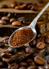 Coffee beans and a metal spoon with ground coffee