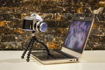 A photo of an old analog film camera using a computer 