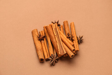 Heap of cinnamon sticks and anise stars on color background