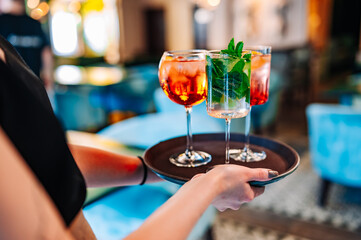 glasses alcohol cocktail set on a waiter tray in bar