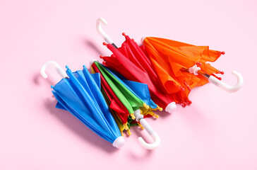 Different mini umbrellas on pink background
