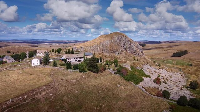Drone sur le Pic de Marchastel dans l'Aubrac - Vue panoramique avec pr&eacute;s & village typique