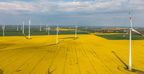  grüne Energiegewinnung Windräder in Landschaft mit Rapsfeld