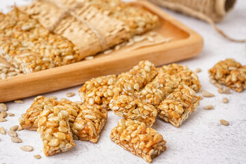 Board with tasty kozinaki and rope on white background