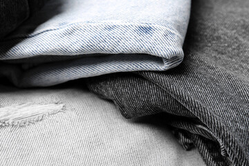 Different stylish denim jeans as background, closeup