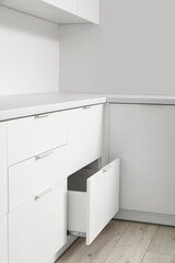Open white drawer in light kitchen