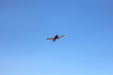 Fototapeta na wymiar A sporty little plane flies beautifully against a blue sky