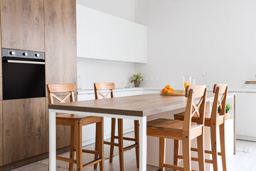 Wooden table and chairs in interior of light kitchen