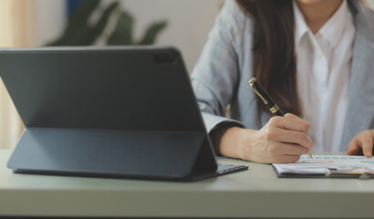 Fototapeta premium Portrait of Asian young female working on laptop at office