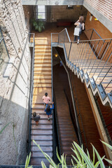A descent with wooden stairs and a black metal