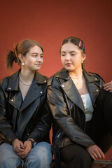 Portrait of young beautiful girls girlfriends in dark jackets.