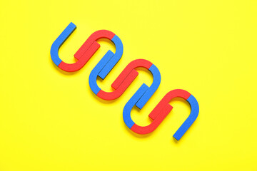 Horseshoe shaped magnets on yellow background
