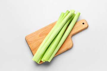 Board with fresh leeks on grey background