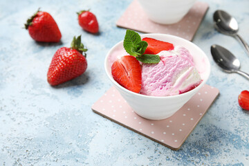 Bowl of strawberry ice cream and spoons on grunge background, closeup