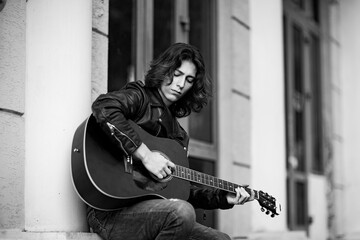 Black and white photo,young, handsome man, brunette with long hair,musician,walking around the city...