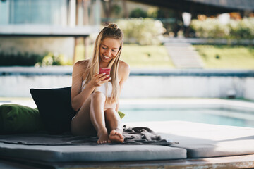 Summer vacation beach luxury resort hotel holiday tropical rest background - young beautiful happy sexy Caucasian smiling girl relaxing near pool lounger reading chat in mobile phone