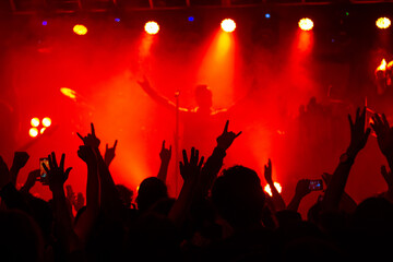Naklejka na ściany i meble Concierto en vivo de Rock Metal, con publico enardecido, vibrando al son de la musica extrema. En un escenario con juego de luces, humo y sombras