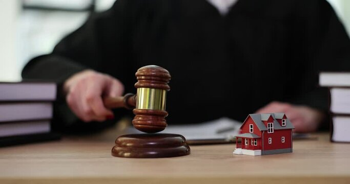 Judge knocks judge wooden gavel on background of house. Seizure of debtor property