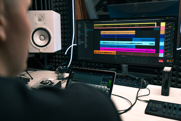 recording studio sound engineer producer mixes songs on screen colorful audio tracks professional...