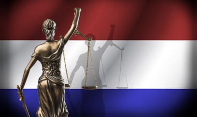 Netherlands flag and a golden statue of justice with scales